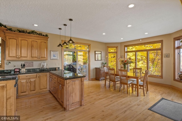 kitchen featuring light wood-style floors, a textured ceiling, a peninsula, recessed lighting, and baseboards