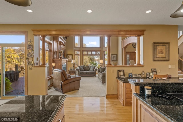 kitchen with recessed lighting, light wood-style floors, and dark stone countertops