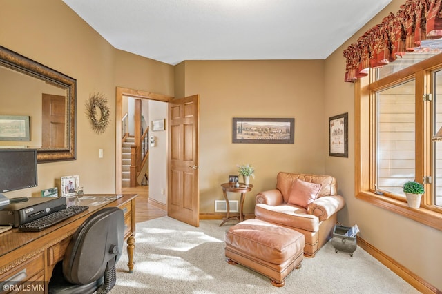 carpeted office space with baseboards and visible vents
