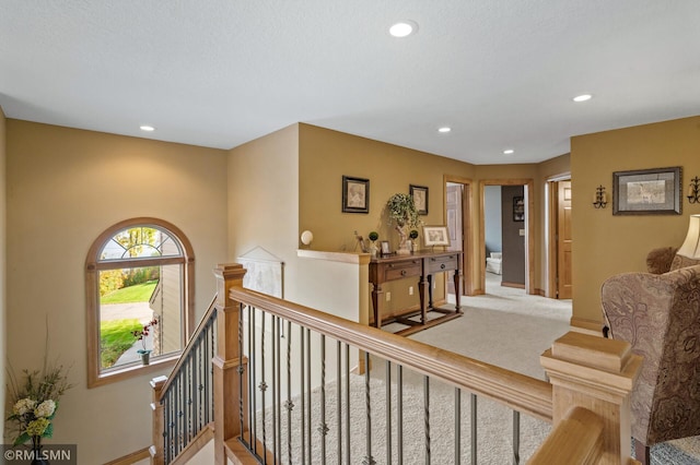 corridor with baseboards, recessed lighting, and an upstairs landing
