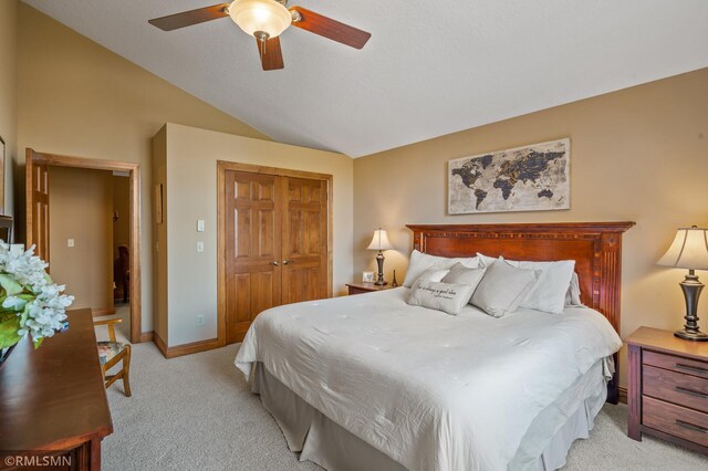 bedroom featuring a closet, baseboards, ceiling fan, light colored carpet, and vaulted ceiling