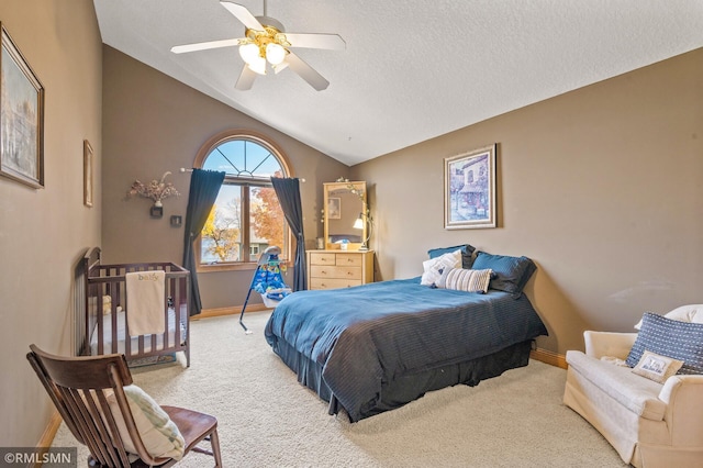 carpeted bedroom featuring baseboards, a textured ceiling, ceiling fan, and lofted ceiling