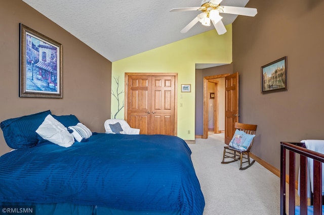 bedroom with a textured ceiling, light colored carpet, vaulted ceiling, baseboards, and a closet