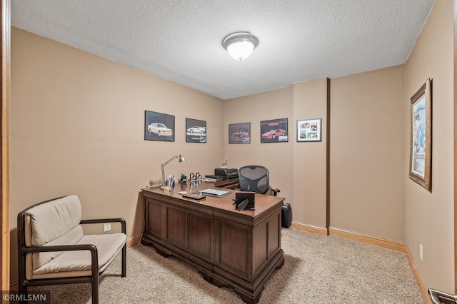 office space with a textured ceiling, baseboards, and light colored carpet