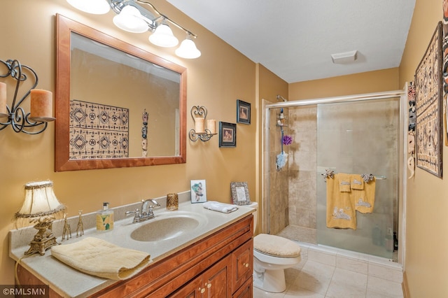 full bathroom featuring vanity, tile patterned floors, a stall shower, and toilet