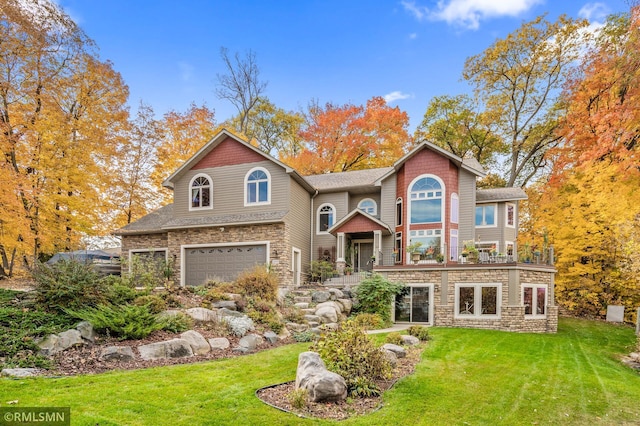 view of front of home with an attached garage, stone siding, and a front lawn