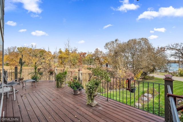 wooden deck featuring a water view and a yard