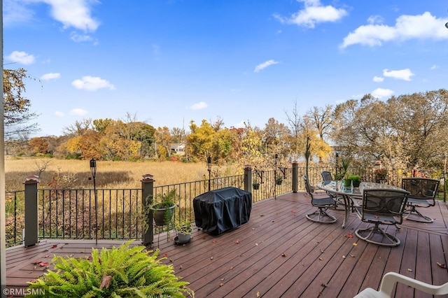 wooden deck with outdoor dining space and a grill
