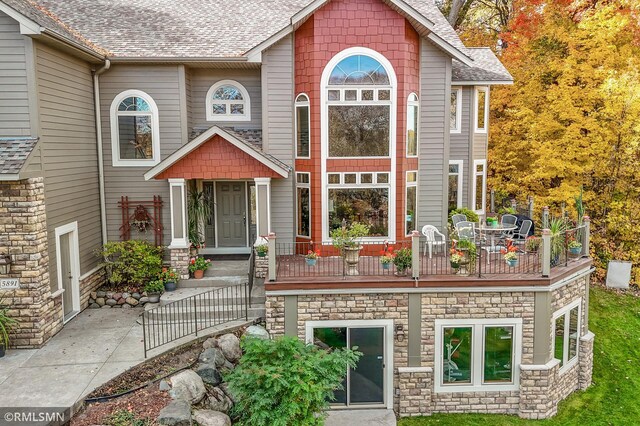 rear view of property featuring a shingled roof