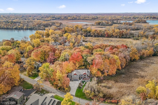 drone / aerial view with a water view and a forest view