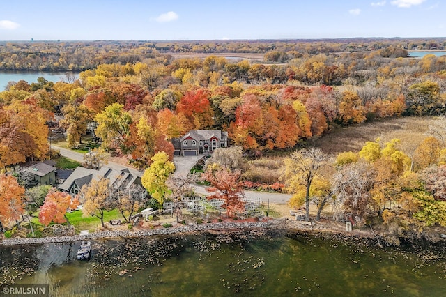 drone / aerial view featuring a view of trees and a water view