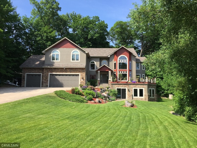 view of front of property featuring an attached garage, concrete driveway, a front yard, and stone siding