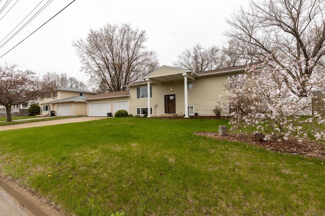 view of front of house featuring concrete driveway, a front yard, and a garage