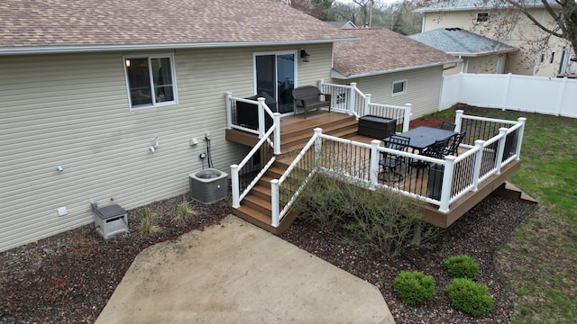 rear view of house featuring fence, a shingled roof, cooling unit, and a wooden deck