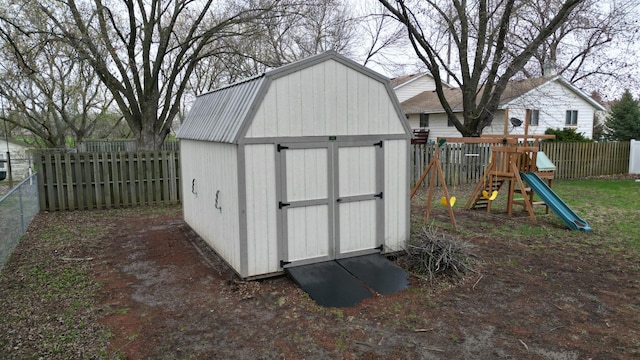 view of shed featuring a fenced backyard and a playground
