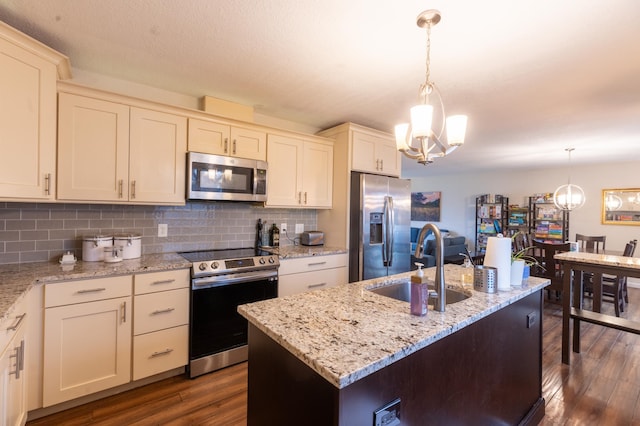 kitchen featuring dark wood-style flooring, a notable chandelier, a sink, stainless steel appliances, and backsplash