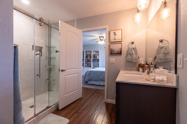 ensuite bathroom featuring wood-type flooring, ensuite bathroom, a stall shower, and vanity
