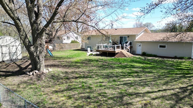 308 16th Ave SW, Austin, MN 55912 - rear view of property featuring a yard, an outbuilding, fence, a wooden deck, and a storage unit