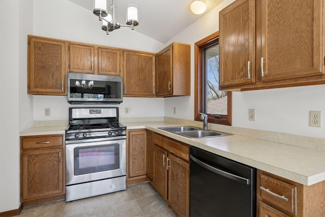 kitchen featuring light countertops, brown cabinets, a sink, appliances with stainless steel finishes, and vaulted ceiling