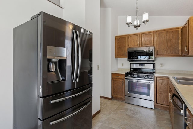 kitchen with an inviting chandelier, brown cabinetry, appliances with stainless steel finishes, and light countertops