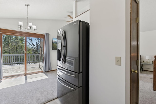 kitchen featuring stainless steel fridge, a notable chandelier, hanging light fixtures, and light colored carpet