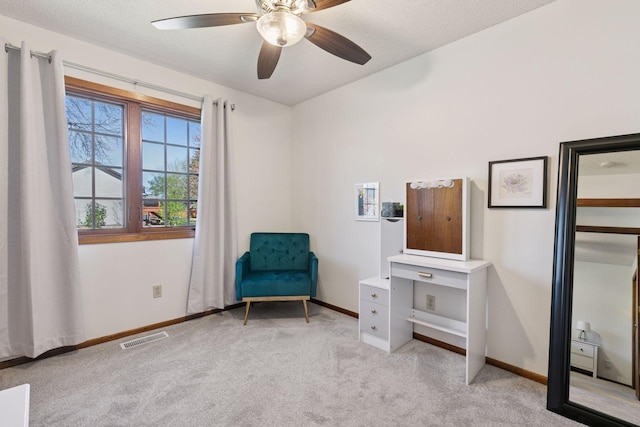 sitting room with baseboards, visible vents, light carpet, and ceiling fan