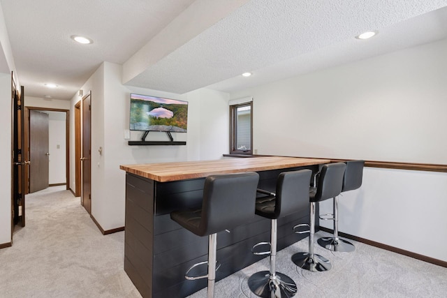 bar with light colored carpet, recessed lighting, and baseboards