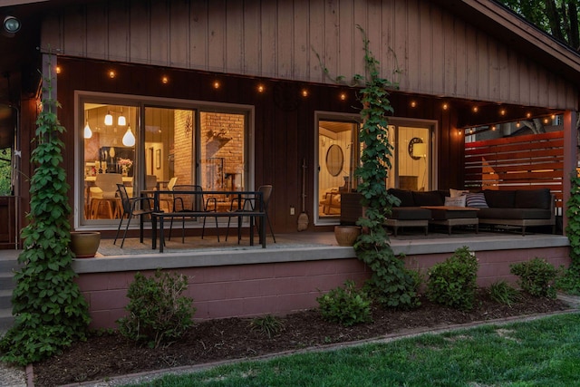 rear view of property featuring covered porch and outdoor lounge area