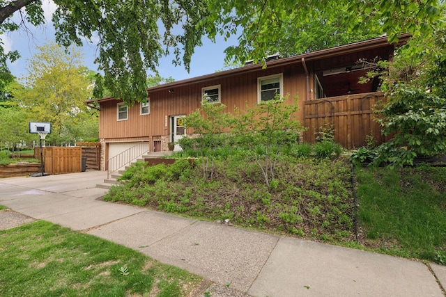 raised ranch with driveway and an attached garage