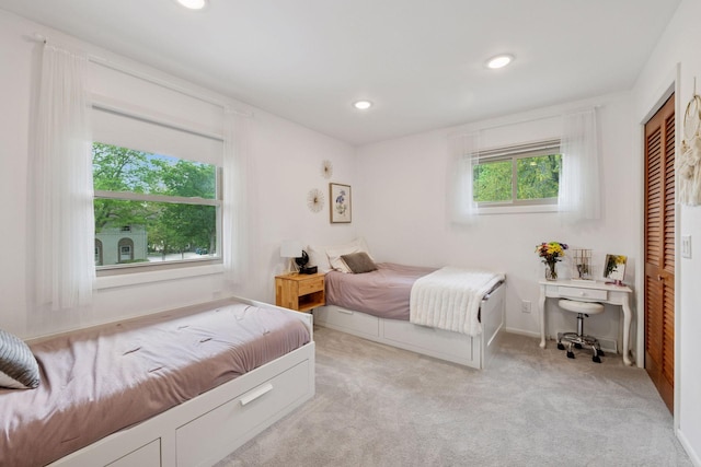 bedroom featuring recessed lighting, light colored carpet, and a closet