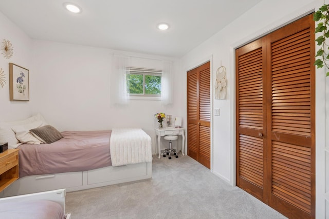 bedroom with two closets, carpet, and recessed lighting