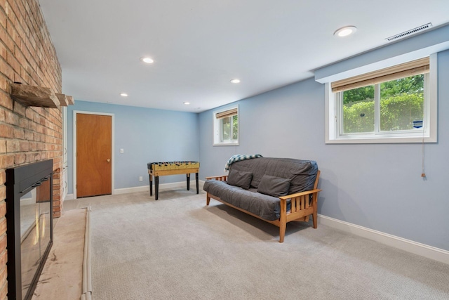 sitting room featuring a brick fireplace, light colored carpet, recessed lighting, and baseboards