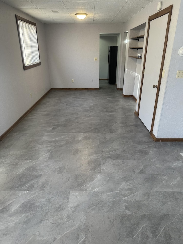 153 10th Ave N, Waite Park, MN 56387 - unfurnished room with concrete flooring, baseboards, and a paneled ceiling