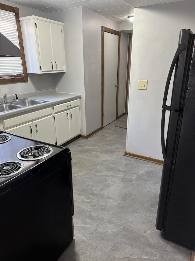 153 10th Ave N, Waite Park, MN 56387 - kitchen with white cabinets, a sink, black appliances, and light countertops