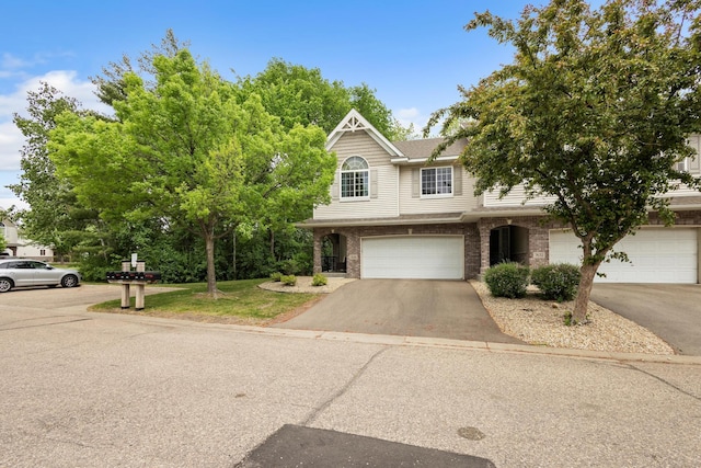 view of front of house with brick siding, asphalt driveway, and an attached garage