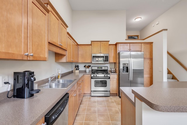 kitchen with stainless steel appliances, a sink, and light tile patterned floors