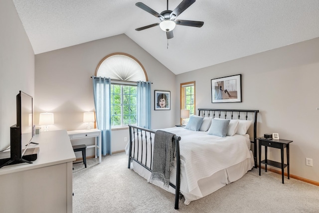 bedroom with lofted ceiling, light colored carpet, baseboards, ceiling fan, and a desk
