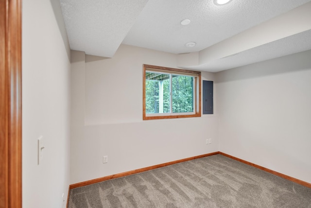 carpeted spare room featuring electric panel, baseboards, and a textured ceiling