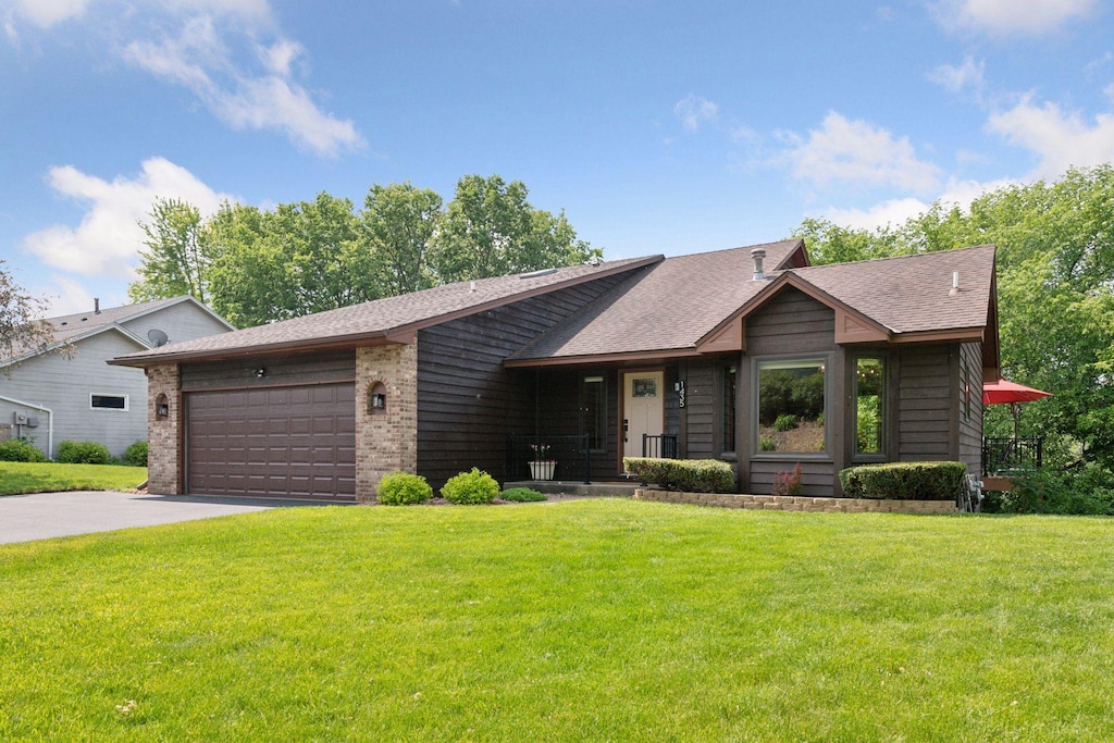 1435 Eastlake Dr, Chaska, MN 55318 - mid-century home featuring an attached garage, a front lawn, driveway, and roof with shingles
