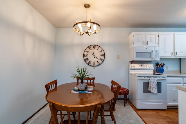 dining area with a chandelier and light wood-style flooring