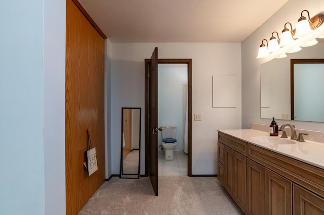 bathroom with toilet, tile patterned floors, and vanity