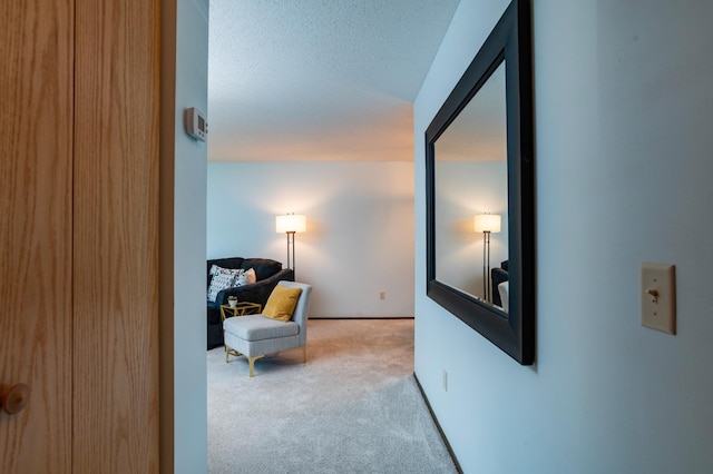 corridor featuring a textured ceiling and carpet flooring