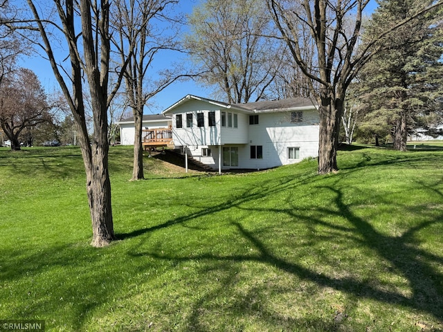 exterior space featuring a lawn, a wooden deck, and stairs