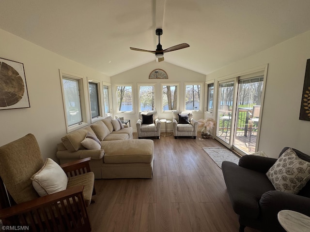 living area with vaulted ceiling, ceiling fan, a water view, and wood finished floors