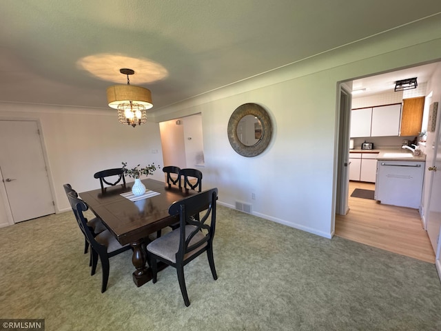 dining space featuring light colored carpet, baseboards, and visible vents