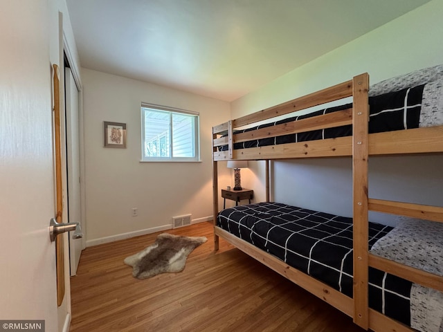 bedroom featuring visible vents, wood finished floors, and baseboards