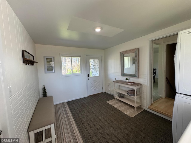 entrance foyer featuring stacked washer and clothes dryer and carpet floors