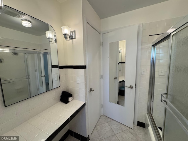 bathroom with a stall shower and tile patterned flooring