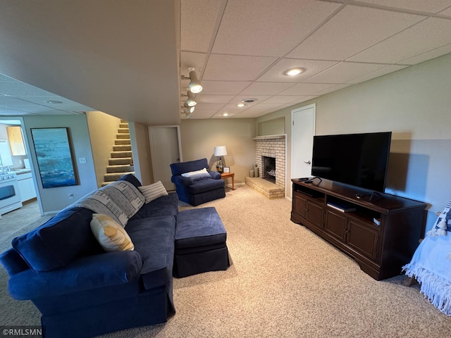 living area with carpet, recessed lighting, stairway, a brick fireplace, and a paneled ceiling