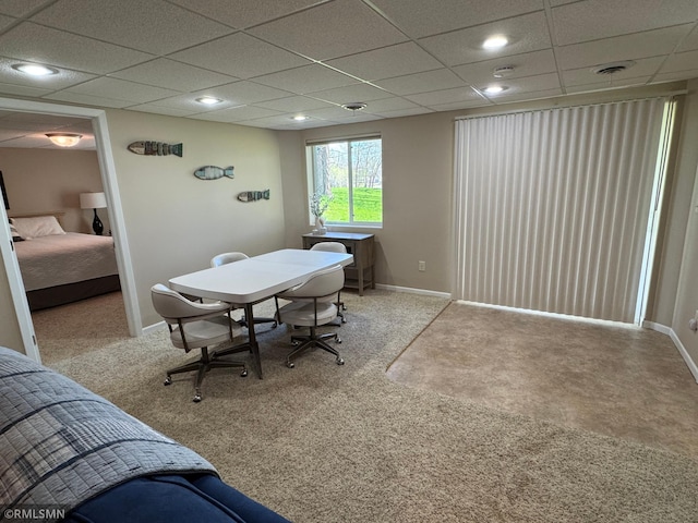 dining area featuring a drop ceiling, baseboards, and carpet floors